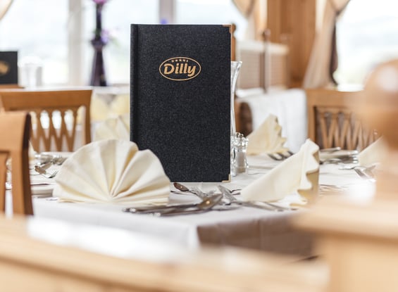 Speisekarte des Hotel Dilly auf einem gedeckten Tisch