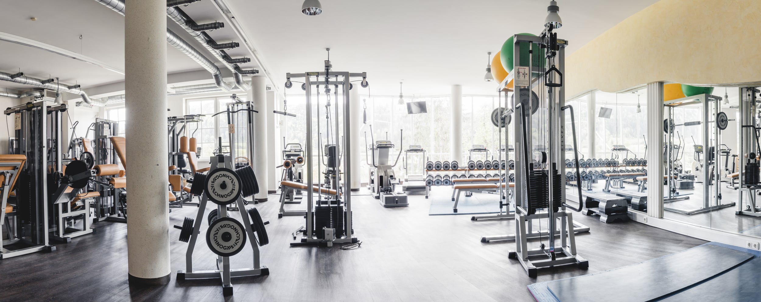 Großer, heller Panorama-Fitnessraum mit modernen Geräten im Sporthotel in Winschgarsten