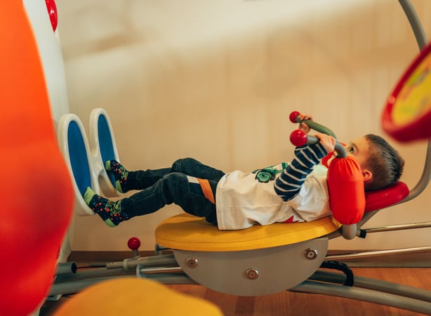 Kleiner Bub trainiert im Kinderfitnessstudio im Hotel Dilly