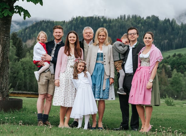 Familie Dilly in Tracht im Garten stehend