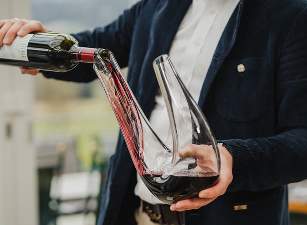 Flasche Rotwein wird in den Dekanter geleert