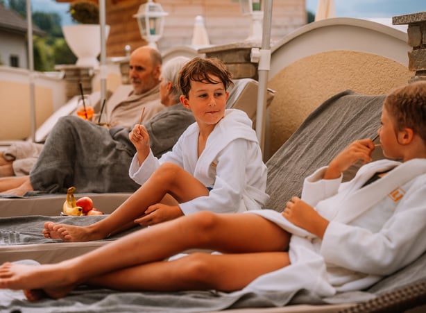 Familie liegt auf Liegen am Pool im Dilly Resort