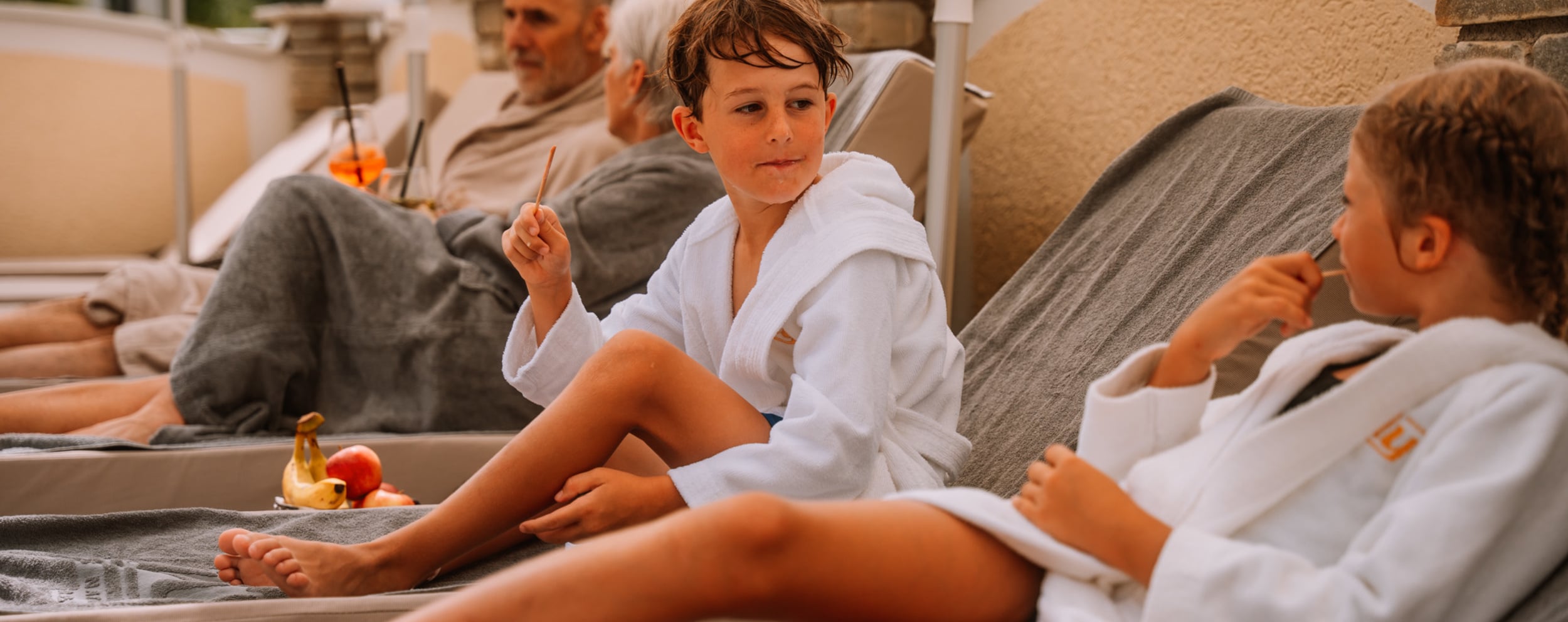 Familie liegt auf Liege am Pool im Dilly Resort