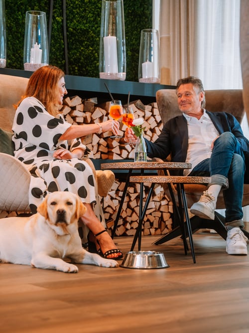 Paar sitzt im Dilly Resort in der Lobby mit Hund