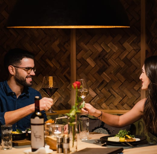 Junges Paar mit Weinglas beim romantischen Dinner im Hotelrestaurant Dilly