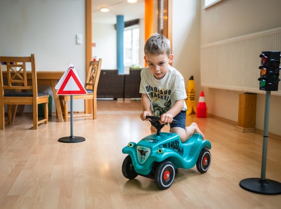 Boy on bobby car in the children's playroom