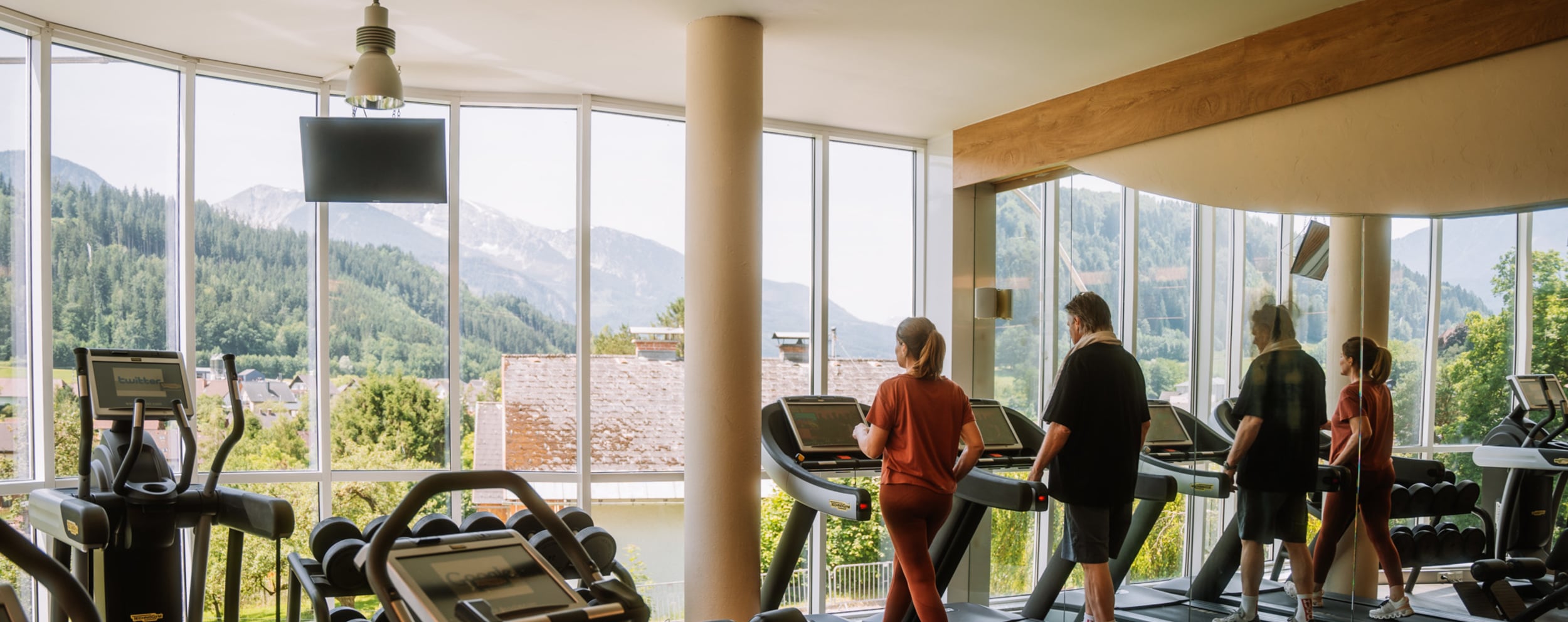 Großer, heller Panorama-Fitnessraum mit modernen Geräten im Sporthotel in Winschgarsten