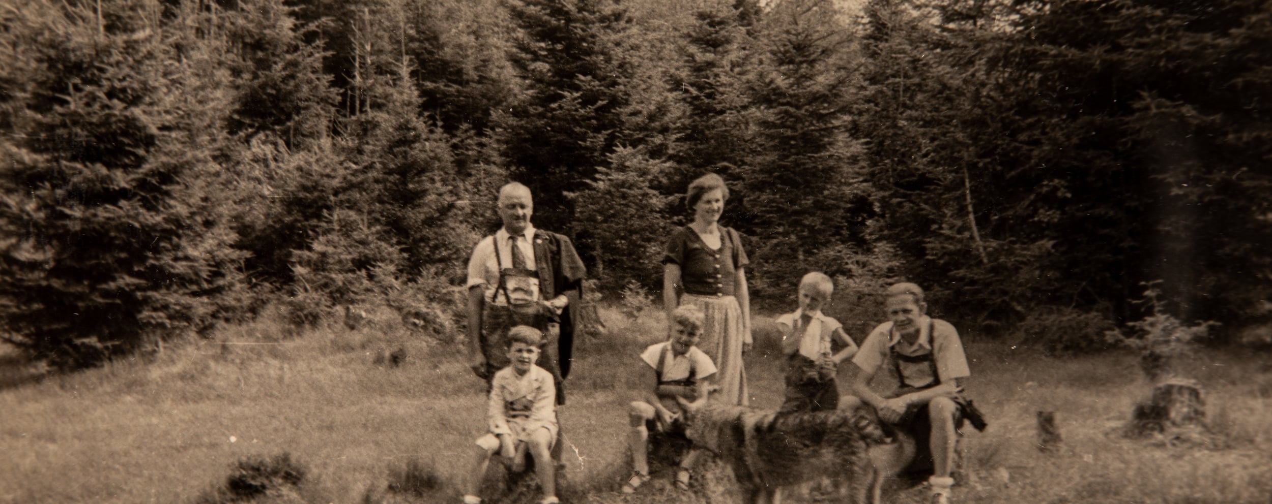 An old photograph of the Dilly family in a clearing in the forest