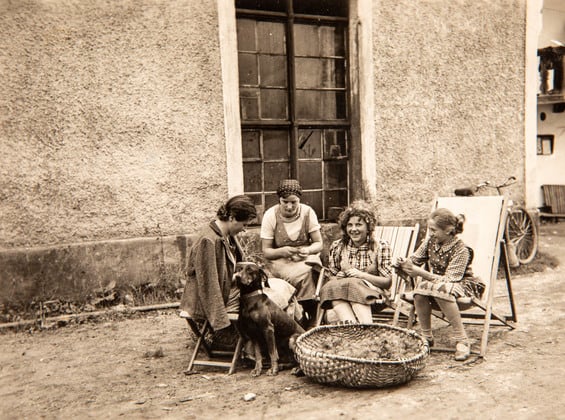 An old photo of the Dilly ladies with the dog, sitting on folding chairs and making something