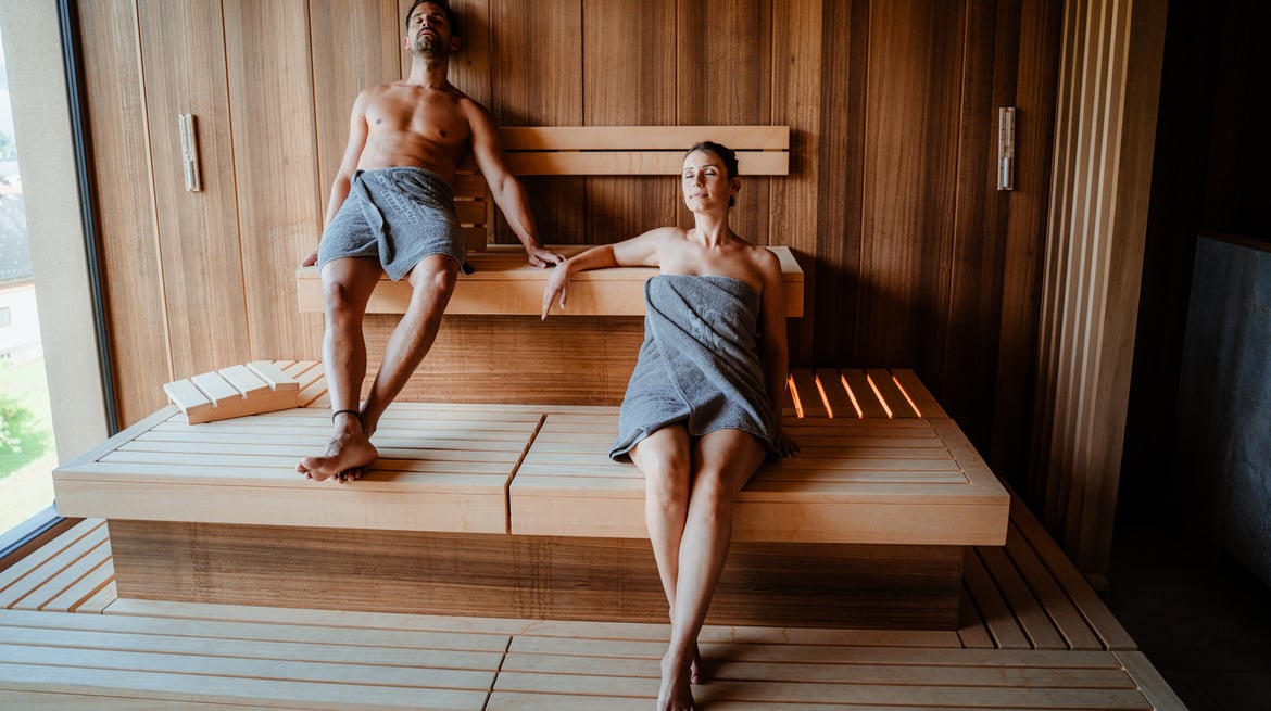 Mann und Frau mit Handtuch in einer Sauna