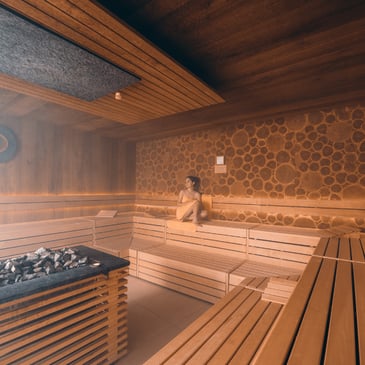 Frau mit Handtuch sitzt in der Sauna