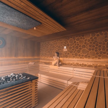 Frau mit Handtuch sitzt in der Sauna