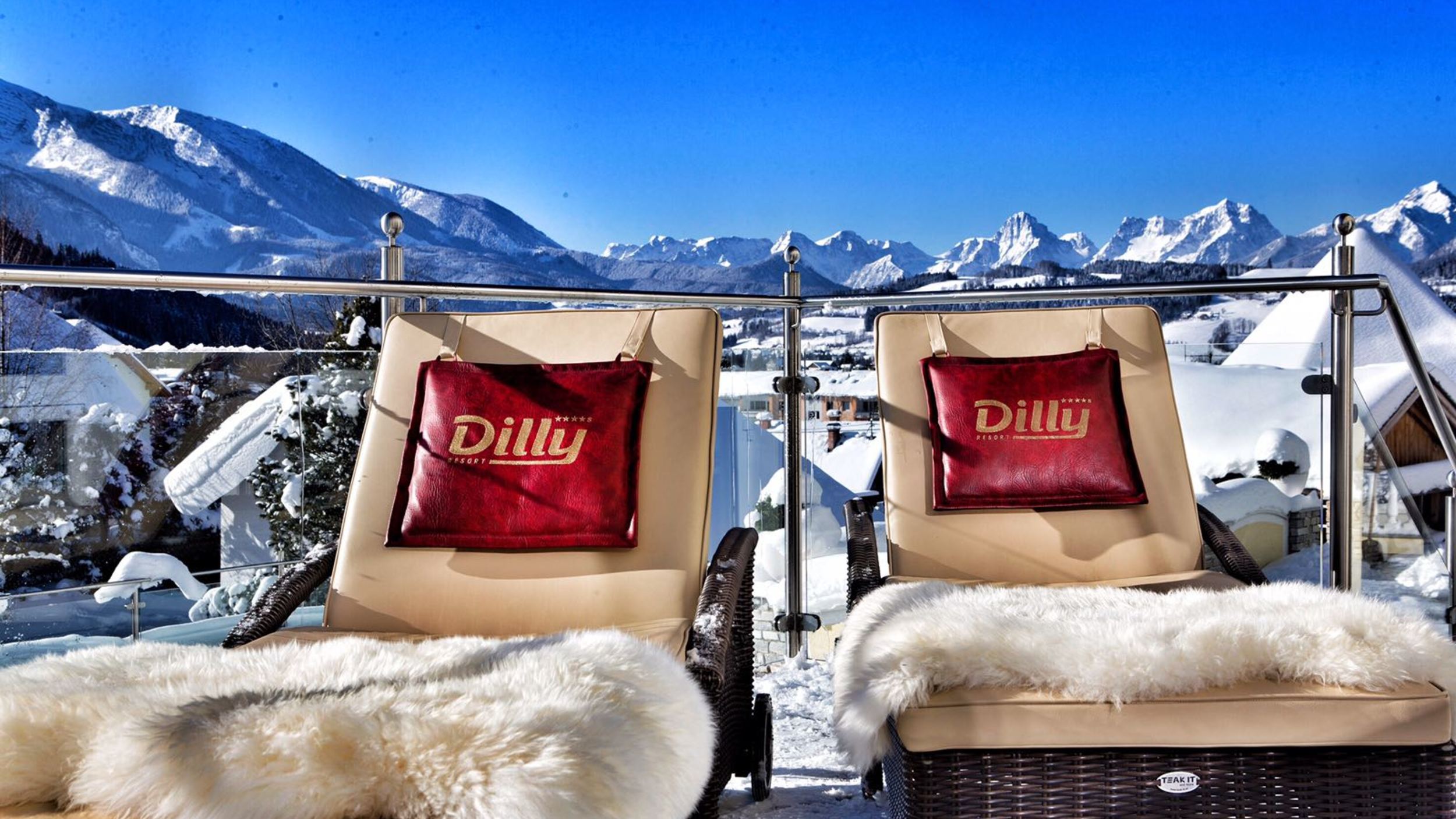 Zwei kuschelige Liegen mit Felldecke auf der winterlich sonnigen Terrasse des Wellnesshotels Dilly